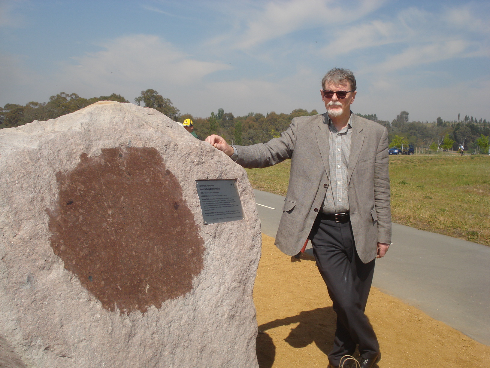 Mike Smith with the Northern Territory’s Mount Goyder Syenite, Proterozoic rock from the Mount Bundey Quarry, just south of Darwin. A face of the rock, just next to the plaque, has been polished to show its colour.