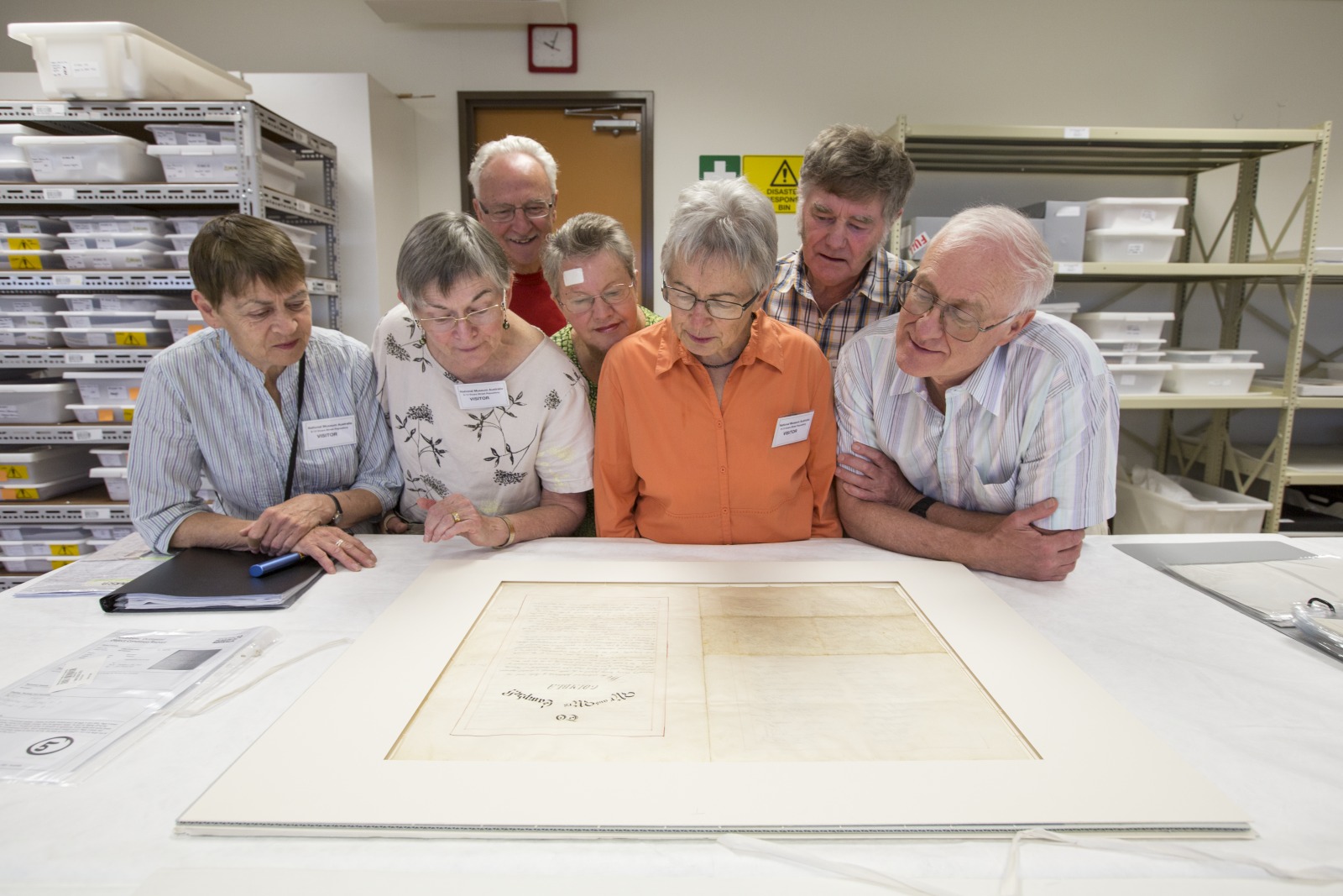The four reunited Campbell descendants, joined by two of their spouses, celebrate their family history by inspecting the letter of sympathy presented to David and Amelia by the inhabitants of Forbes. Photo by Jason McCarthy, National Museum of Australia