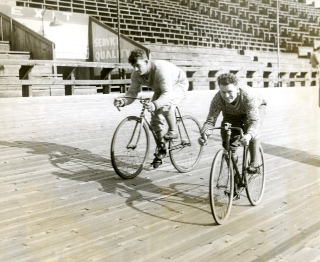 Caption reads: Six Day Bike Riders at the Newark Velodrome, N.J. preparing for the 43rd International Six Day Bike Race to be held at Madison Square Garden – On the left is Reggie McNamara, the champion of America and Emile Aerts, of Belgium, right, is the champion of Europe. Source: National Museum of Australia 