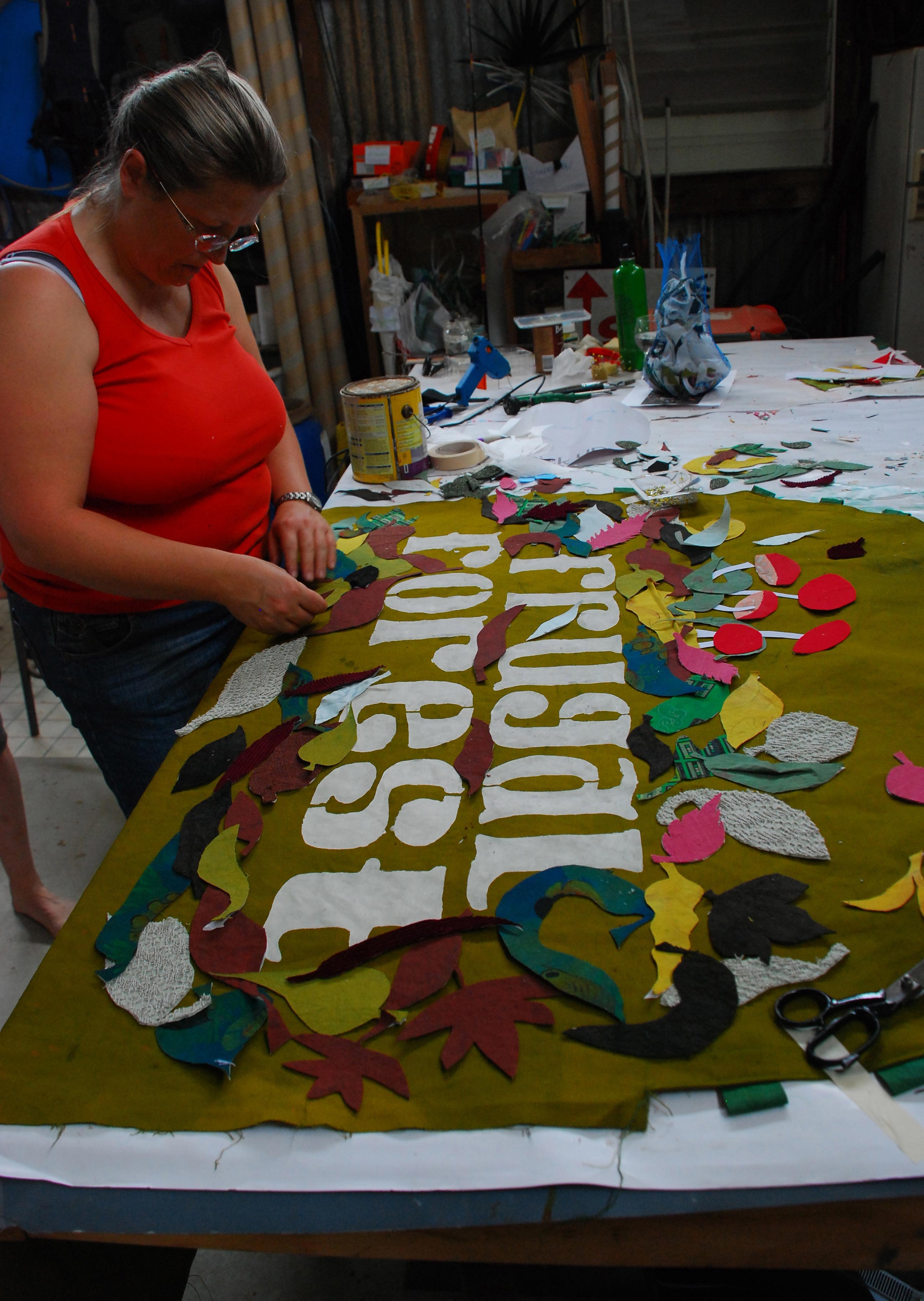 Irene Dowton doing some fine handwork on the Frugal Forest collection cart sign. Photo: Bryony Anderson.