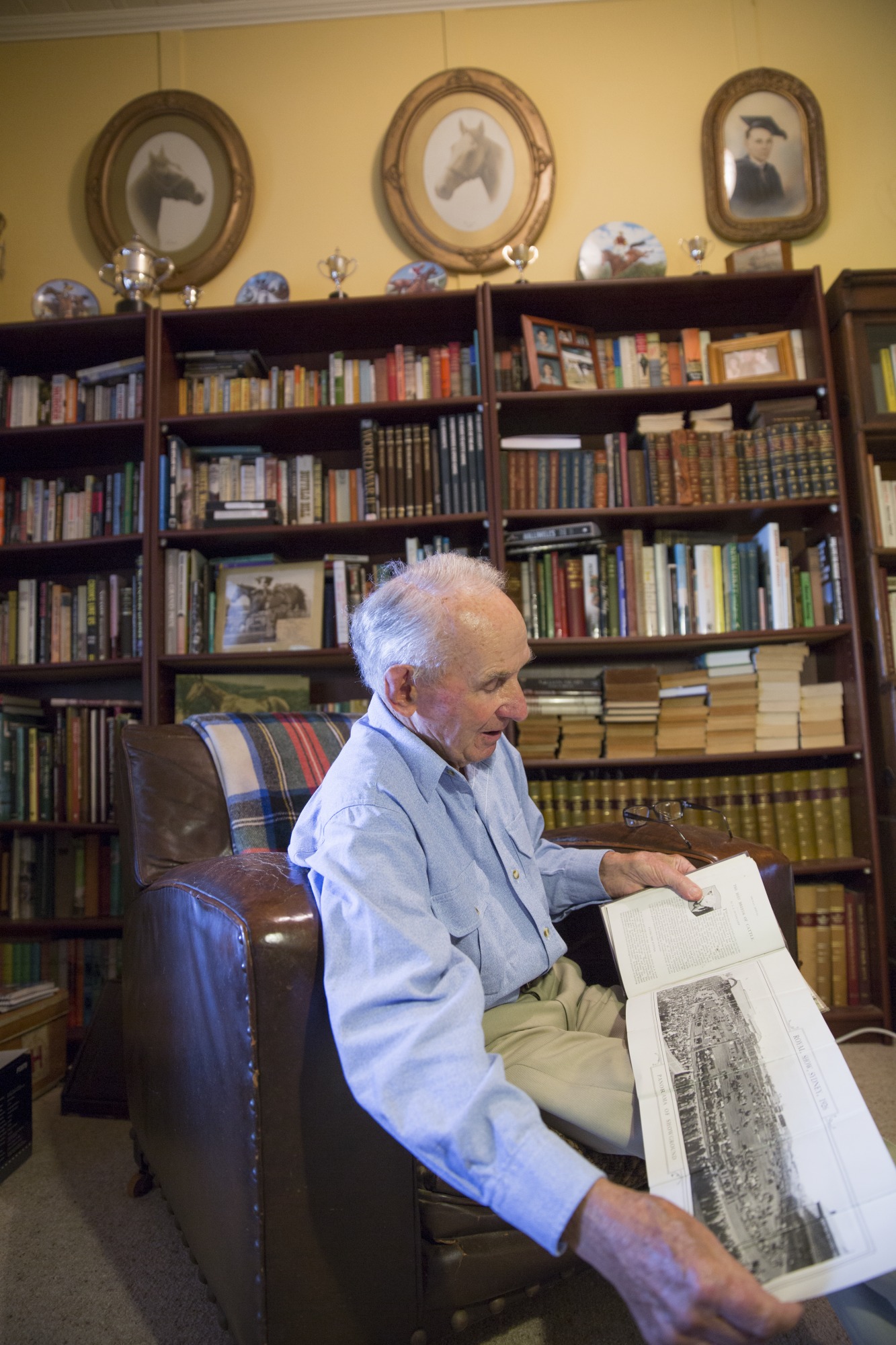 Man sitting in chair looking at photograph