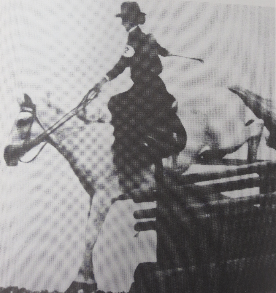 Woman jumping horse using sidesaddle