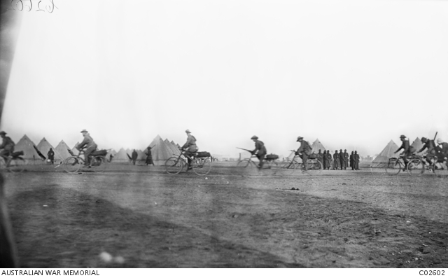 Australians, possibly members of the Anzac Cyclists Battalion, cycling past tent lines, probably at Heliopolis camp, near Cairo. 1915 Australian War Memorial